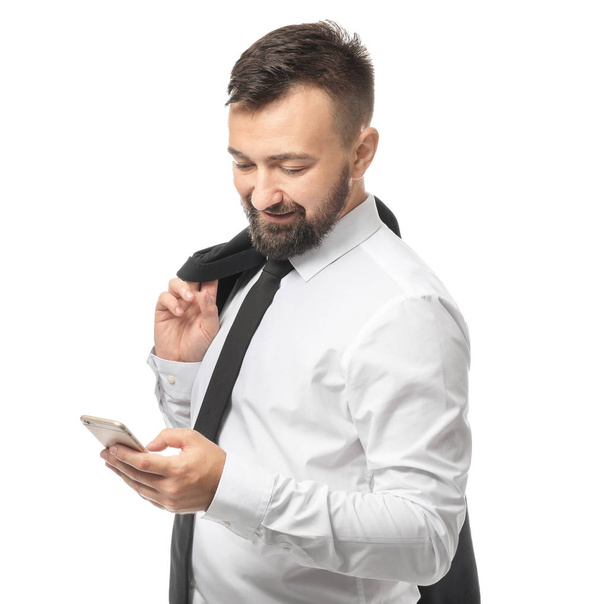 Smiling businessman with mobile phone on white background - Fotó, kép