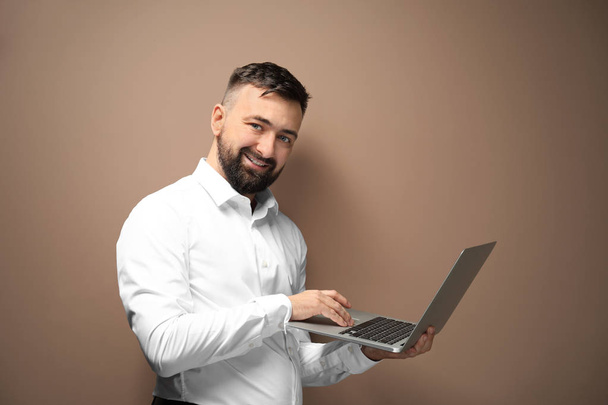 Homme d'affaires prospère avec ordinateur portable sur fond de couleur
 - Photo, image