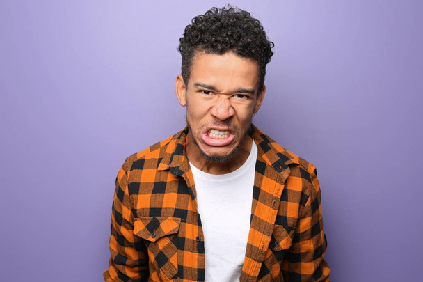 Portret van agressieve Afro-Amerikaanse man op kleur achtergrond - Foto, afbeelding