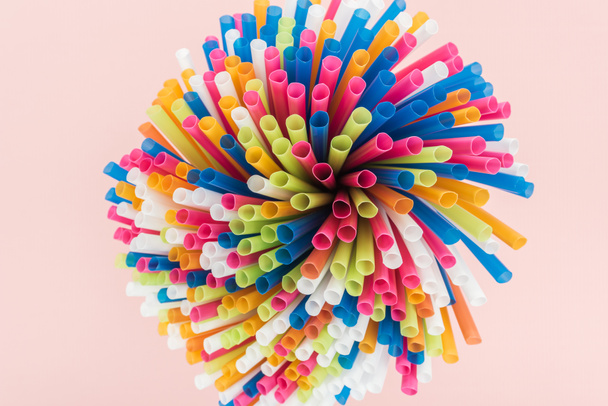 top view of colorful and bright plastic straws isolated on pink - Foto, immagini
