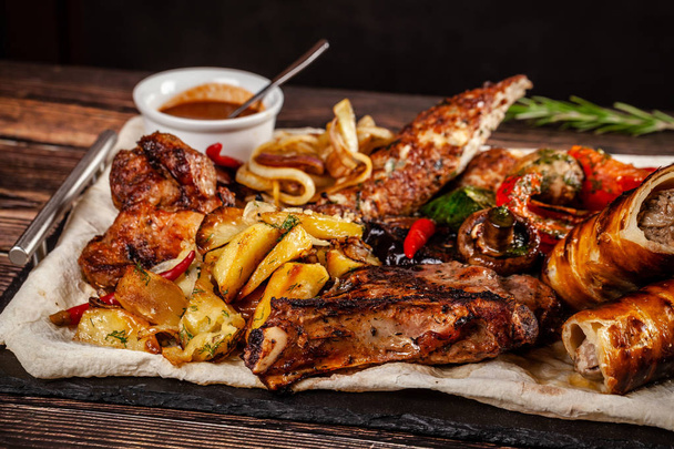 Concept of Georgian cuisine. Large meat board with shashlik, roasted meat, french fries, roast lamb and sauce. Serving dishes in a restaurant on a pita. Top view, copy space - Fotoğraf, Görsel