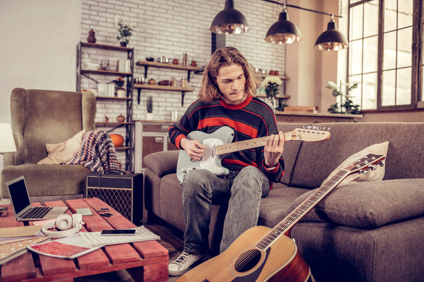 Blonde-haired student with bob cut playing his new little guitar - Fotografie, Obrázek