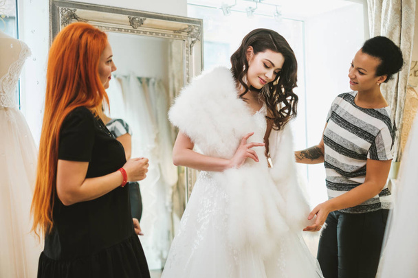Beautifu bride choosing wedding dress in a wedding salon - Photo, Image