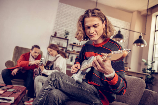 Teenager with bob cut smiling while feeling joyful composing music - Zdjęcie, obraz