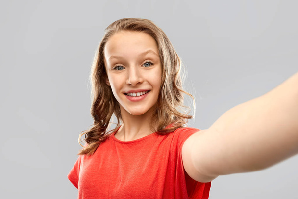 smiling teenage girl taking selfie - Фото, изображение
