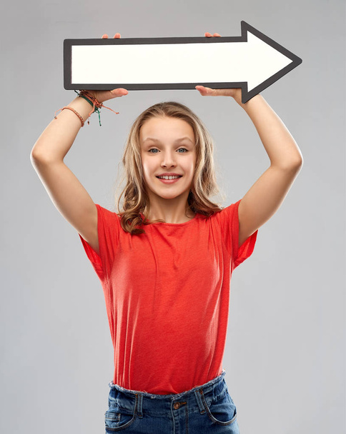 smiling teenage girl with arrow showing direction - Foto, Imagen
