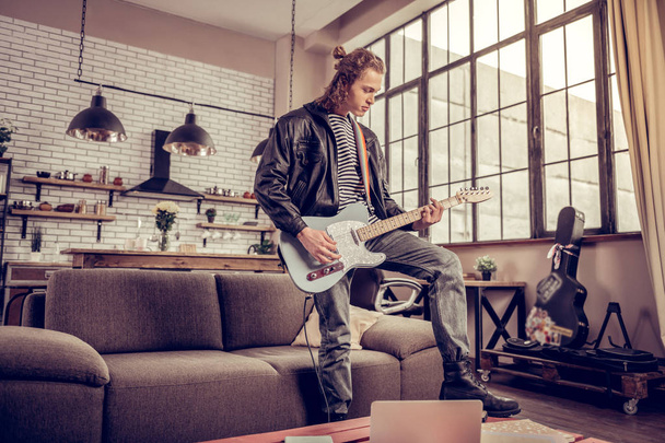 Participant of rock band having rehearsal in the living room - 写真・画像
