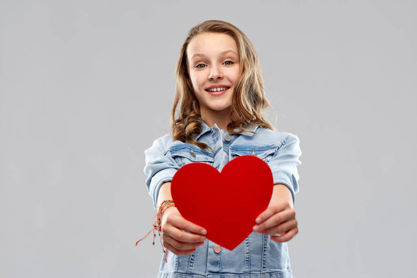 smiling teenage girl with red heart - Фото, изображение