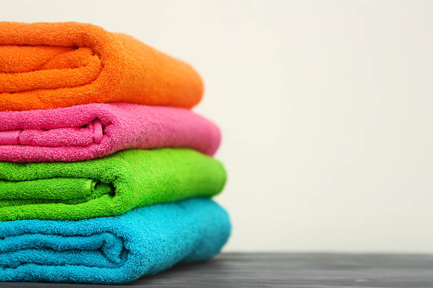 Zásobník ručníků světlé barvy na stole proti světlé pozadí - Fotografie, Obrázek