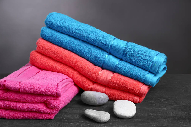 Miękkie ręczniki spa kamienie na stół ciemny - Zdjęcie, obraz