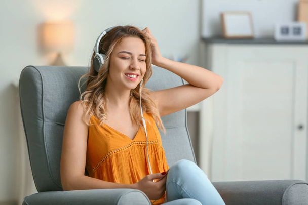 Красива молода жінка слухає музику вдома
 - Фото, зображення
