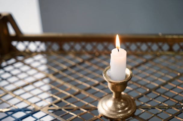 Beautiful burning candle on golden tray - Photo, Image