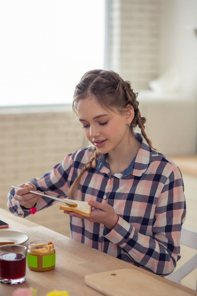 Positive delighted blonde girl looking at sandwich - Foto, Imagem