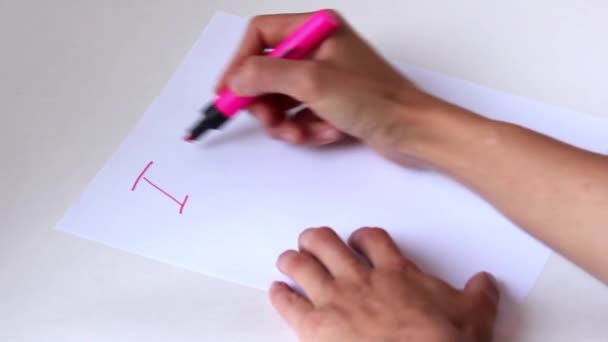 Woman hand with pink pencil writing "I miss you" on white paper - Filmati, video