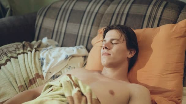 Hirtelen felébred, otthon izgatott fiatalember. 4k - Felvétel, videó