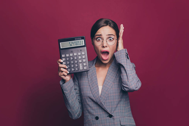 Portrait of nice cute attractive lovely winsome gorgeous nervous scared afraid mad desperate lady in gray checkered jacket showing cash balance isolated over maroon burgundy marsala background - Foto, Bild