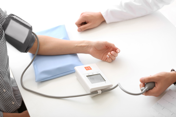 Чоловік-лікар вимірює кров'яний тиск пацієнта в лікарні
 - Фото, зображення