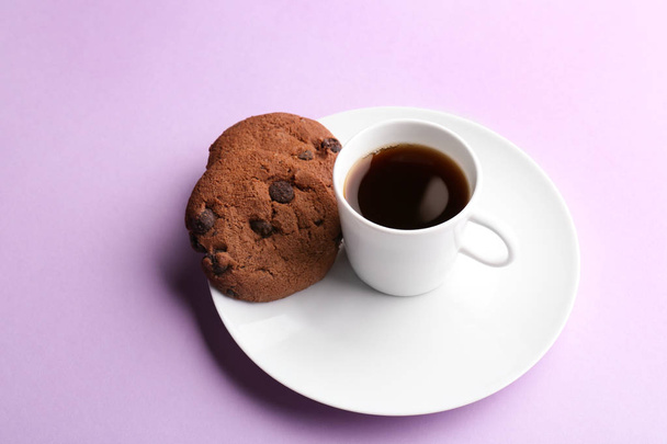 Taza con sabroso café aromático y galletas sobre fondo de color
 - Foto, Imagen