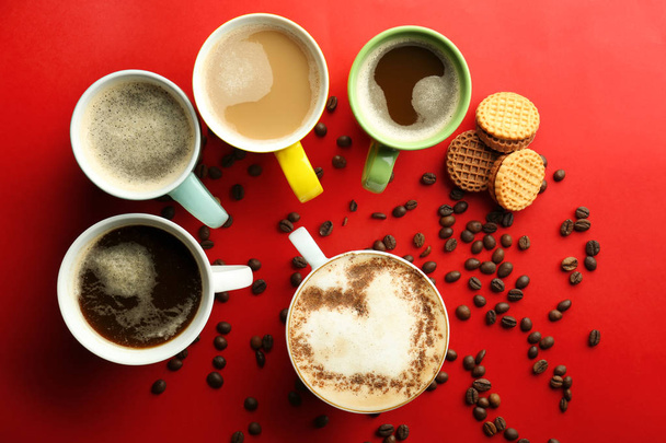 Many cups with tasty aromatic coffee and cookies on color background, flat lay - Photo, Image