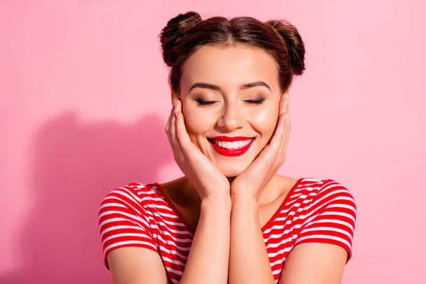 Close up photo beautiful she her lady pretty two buns eyes dreamer closed bright pomade lipstick touch hold arms hands cheeks cheekbones wear casual striped red white t-shirt isolated pink background - Photo, Image