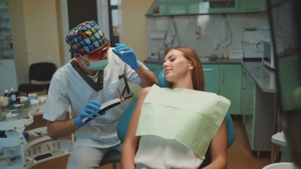 Young pretty girl is in dental cabinet on treatment and consultating. 4K - Video
