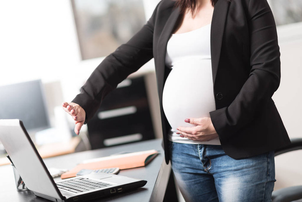 Виснажена вагітна жінка перед ноутбуком
 - Фото, зображення