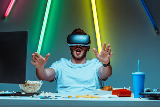 bonito e surpreso homem usando realidade virtual headset no apartamento
  - Foto, Imagem