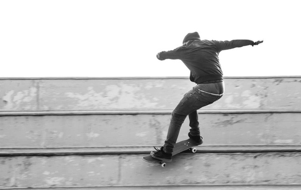 Jongen doet een truc van de grind met skateboard - Foto, afbeelding