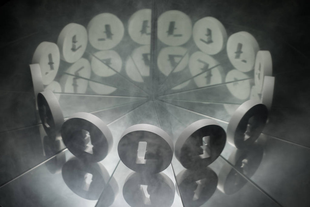 Litecoin Kryptowährungssymbol auf Spiegel und in Rauch gehüllt - Foto, Bild