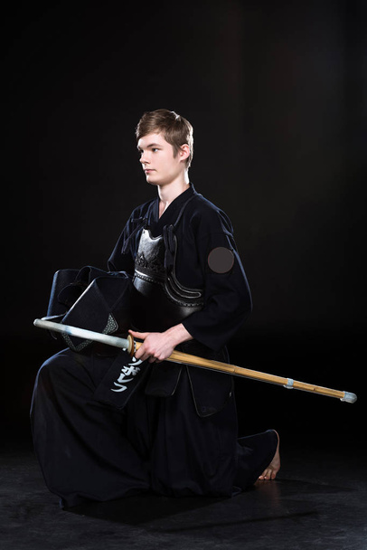 Νεαρός άνδρας εξάσκηση του kendo με sowrd σε μαύρο - Φωτογραφία, εικόνα