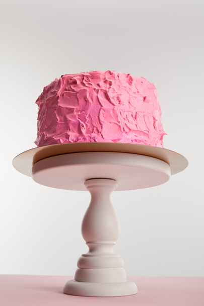 bottom view of sweet pink birthday cake on cake stand on grey - Фото, изображение