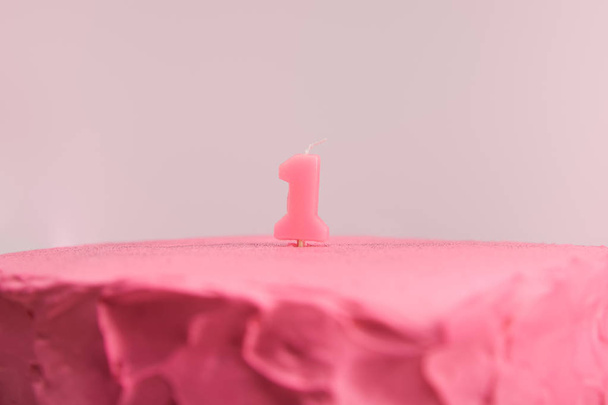 selective focus of number one candle on pink and tasty birthday cake isolated on pink  - Foto, Bild