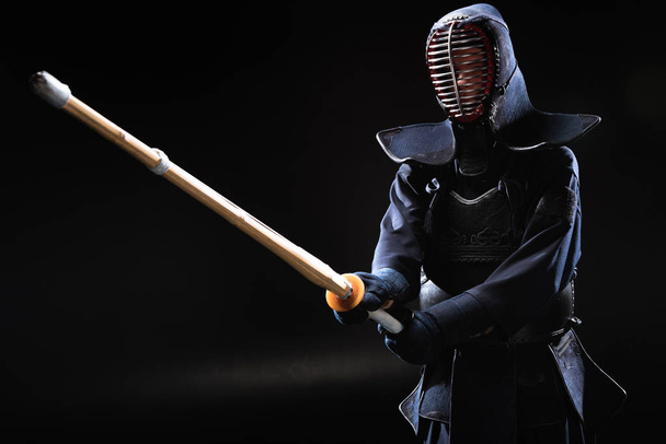 Bojovník Kendo v brnění, cvičit s bambusovým mečem na černém pozadí - Fotografie, Obrázek