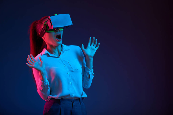 Nagyon érzelmes döbbenve fiatal ázsiai üzleti lady ijesztő játék virtuális-valóság sisak  - Fotó, kép