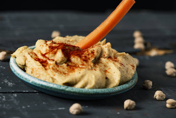 dipping carrot in a homemade hummus - Photo, Image