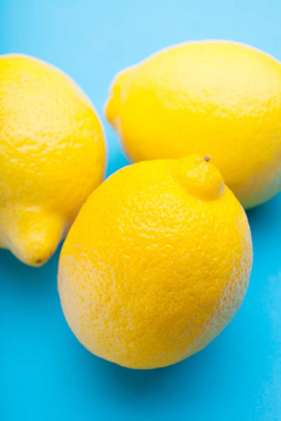 Large exotic lemons on a blue table. - Foto, Bild