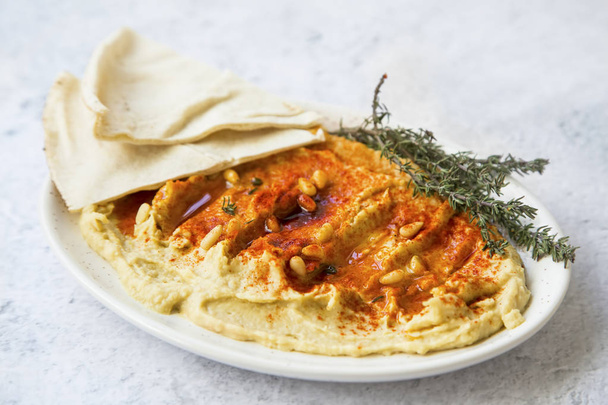 Гумус з паприкою, насінням сосни та ліванським хлібом (піта), здоровий
 - Фото, зображення