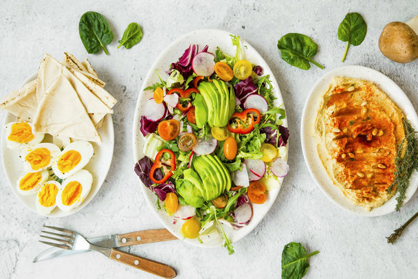 Platos de comidas saludables vista superior con ensaladas de verduras frescas, hummu
 - Foto, imagen