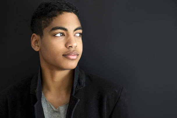 Ritratto di moda di un bel ragazzo su uno sfondo nero. Ritratto di un giovane afroamericano. Attraente adolescente
. - Foto, immagini