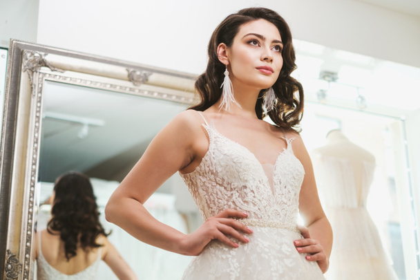 Beautifu bride choosing wedding dress in a wedding salon - 写真・画像