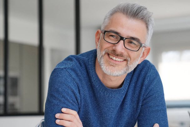 Portrait of smiling man with grey hair and glasses - Foto, Imagem