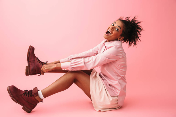 Pretty amazing young african woman posing isolated over pink wall background. - 写真・画像