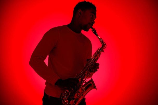 African American jazz musician playing the saxophone. - Фото, изображение