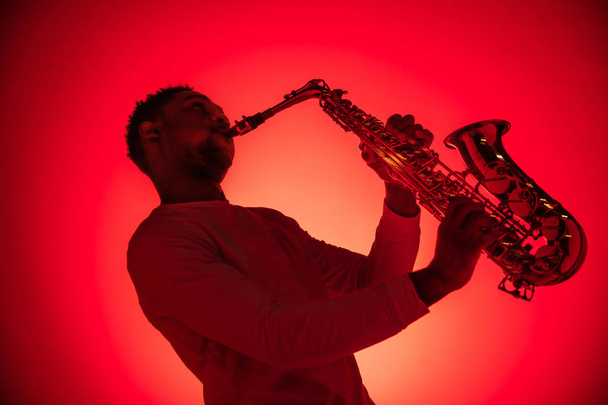 African American jazz musician playing the saxophone. - Фото, зображення