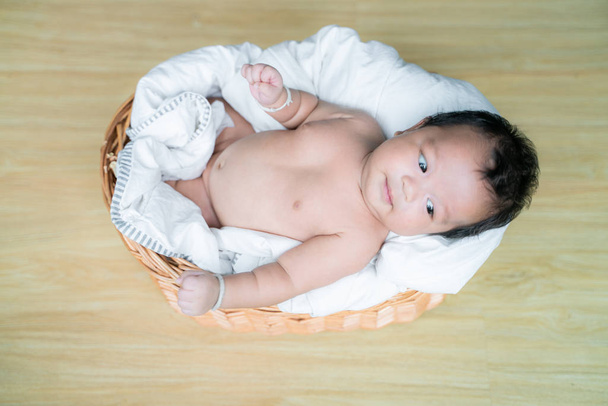 Baby infant boy lying on wood basket top view - Photo, Image