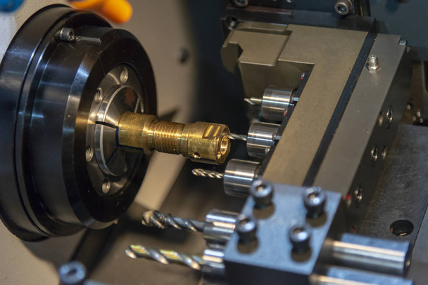The CNC lathe machine drilling the hole on the brass  shaft part - Photo, Image