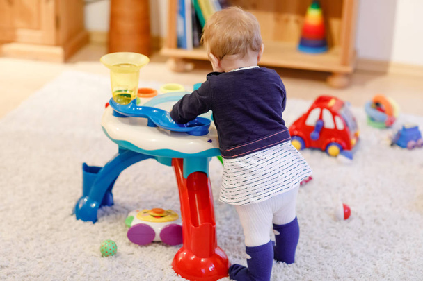 Αξιολάτρευτο χαριτωμένο όμορφο μικρό μωρό κορίτσι παίζει με εκπαιδευτικά παιχνίδια ταξινόμησης στο σπίτι ή στο νηπιαγωγείο. Υγιές ευτυχισμένο νήπιο παιδί μάθηση διαλογή χρώματα και μορφές - Φωτογραφία, εικόνα