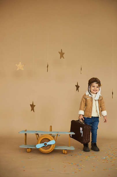 concept of dreams and travels. pilot aviator child with a toy ai - Photo, image