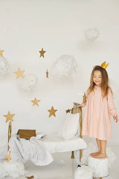 Little princess with a magic wand on  bed in a cloud  - Photo, image