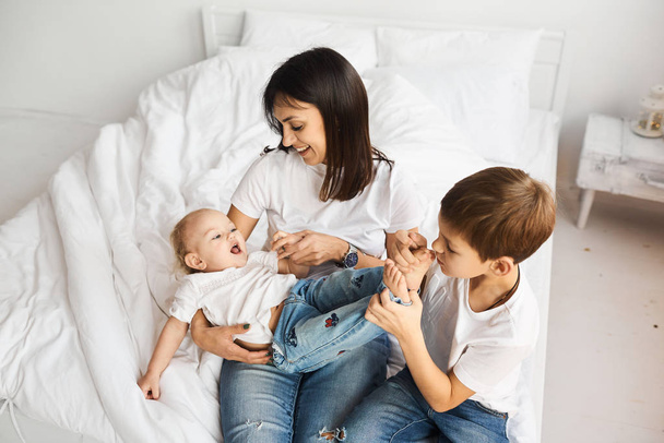happy loving family. mother playing with her children in the bed - Valokuva, kuva
